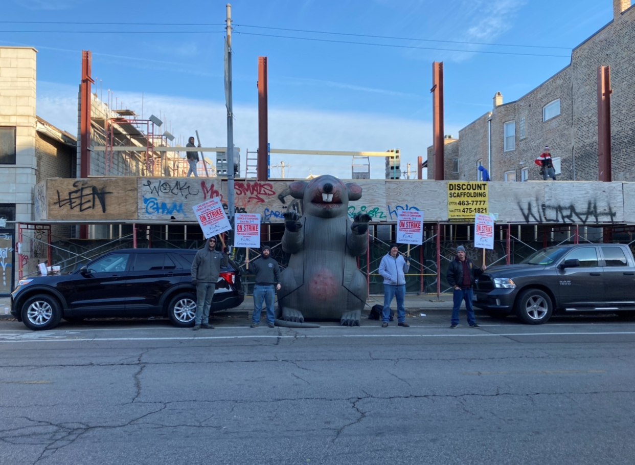 Large inflatable rat with Local 54 picketers